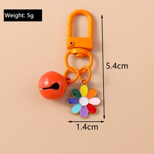 Close-up of orange bell and daisy keychain showing 5.4cm length and 5g weight specs