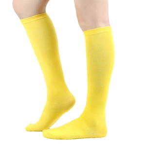 Side view of bright yellow cotton knee-high socks with stripes on female model