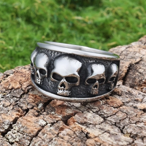 Detailed macro view of vintage stainless steel skull ring on rustic tree bark texture