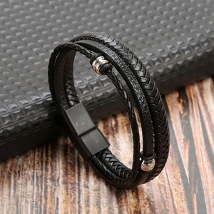 Close-up of black braided leather bracelet with multi-layer metal beads and magnetic clasp