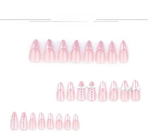 Detailed view of pink almond press-on nails with 3D bows, pearls and lattice patterns