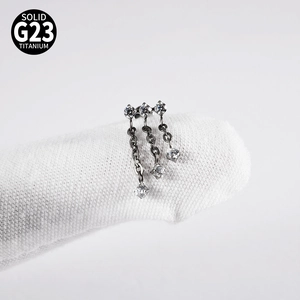 Detailed view of G23 titanium lip stud with triple crystal row and hanging fringe chains