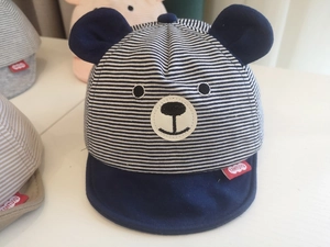 Detail of baby striped baseball cap with bear ears and embroidery in blue and white