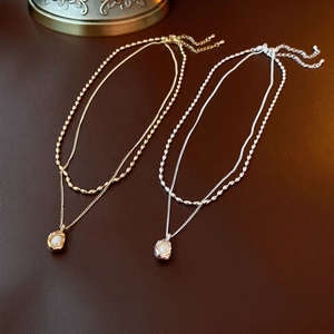 French layered necklace with gold and silver bead chains and elegant pearl pendants