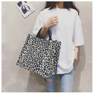 Detail of black and white leopard print canvas tote bag with sturdy woven handles