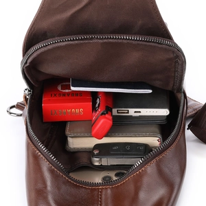 Macro view of leather chest bag showing large capacity interior and smooth metal zipper