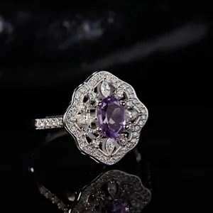 Macro shot of oval amethyst ring with hollow petal halo and sparkling diamonds