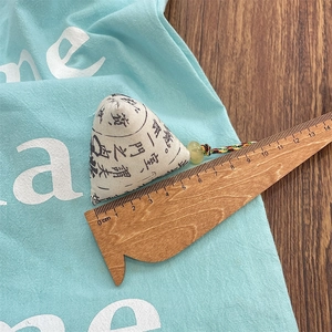 Detail showing white canvas rice dumpling pendant with calligraphy and size scale