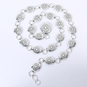 Detailed macro view of silver oval metal links with floral engraving for waist chain belt
