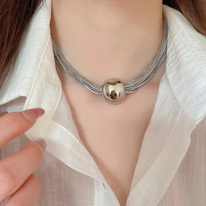 Detail of silver multi-layer chain necklace with a large polished metal ball pendant