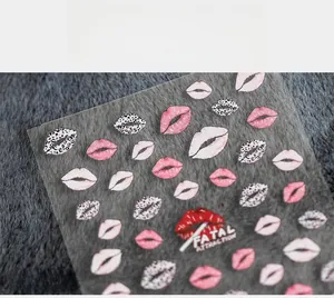 Detailed view of 5D lip print nail decals with leopard and red glitter heart designs