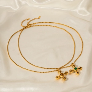 Macro detail of 18k gold stainless steel cross necklace with a green tiger eye stone inlay