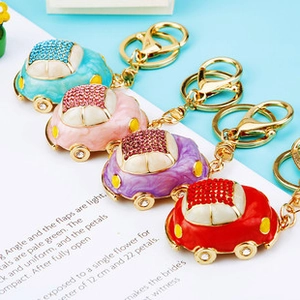 Macro view of crystal encrusted airplane car keychains in assorted vibrant colors