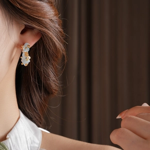 Detail of aquamarine flower pearl earrings on model showcasing gold-tone finish