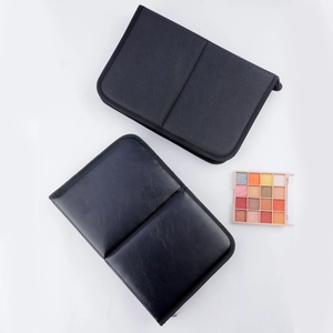 Macro shot of black smooth and textured leather makeup organizers with an eyeshadow palette