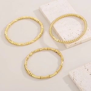 Three 18k gold-plated stainless steel bamboo and beaded bangles on stone plates