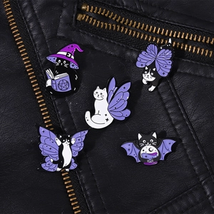 Detail of five Halloween wizard cat enamel pins pinned on a black leather jacket texture