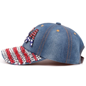 Detail of blue denim baseball cap featuring LA rhinestone patch and striped glitter brim