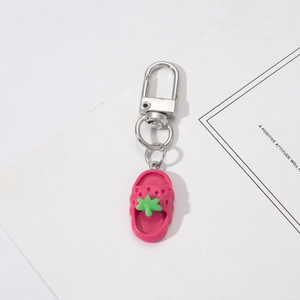 Macro view of a pink clog shoe keychain with green flower charms and silver clasp