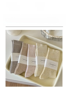 Detail view of five soft cotton ruffle socks in pastel shades with texture details