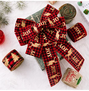 Detailed close-up of Christmas burlap ribbon with reindeer prints on white fur background