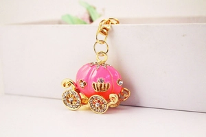 Detail view of pink pumpkin carriage keychain with gold alloy finish and sparkling rhinestones