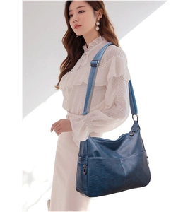 Detail of soft blue PU leather bag with lychee texture and multiple zipper pockets