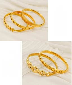 Detailed macro view of high-quality gold-plated stainless steel bangles on white silk fabric