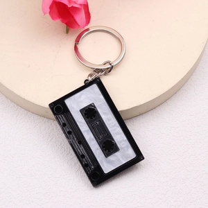 Close-up of a cassette-shaped keychain with marble pattern and To Friend text