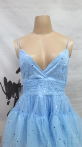 Detail of light blue tulle dress featuring silver star and moon sequin embroidery