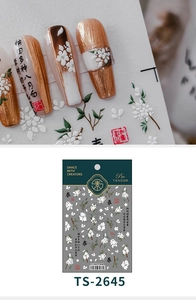 Dettaglio macro di adesivi per unghie 5D con fiori bianchi e calligrafia cinese fine