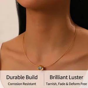 Close-up of a gold-plated necklace featuring a round crystal pendant on a delicate chain