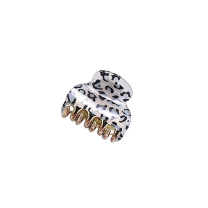 Detailed view of leopard print hair claw clip with golden metal teeth on white background