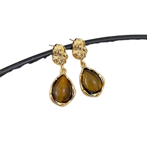 Tiger eye stone flower drop earrings in gold plated finish with silver pins on white background