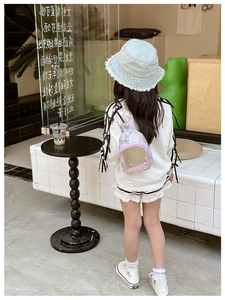 Detail view of purple sequin backpack with transparent layer and stylish child casual outfit