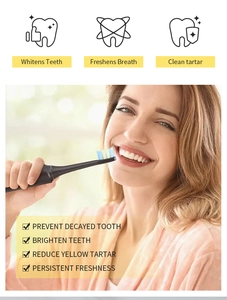 Mujer sonriente usando un cepillo de dientes negro para blanquear los dientes