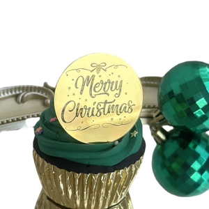 Golden mirror acrylic cake topper with Merry Christmas engraving on green cupcake