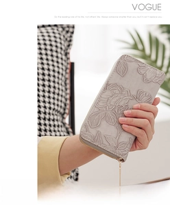 Detail of grey long wallet with 3D embossed rose pattern and golden zipper tassel