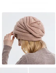 Close-up of pink knitted beanie featuring spiral texture and mountain leather patch