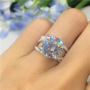 Macro shot of a classic four-prong solitaire ring and nested band set on finger