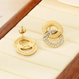 Detailed view of intertwined gold hoop earrings with ribbed texture and micro-pave crystals