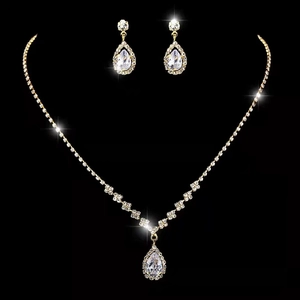 Macro shot of gold bridal jewelry set featuring teardrop crystals and sparkling rhinestones