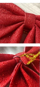 Detail of red glitter Christmas bow featuring a soft sponge core and gold twist tie back