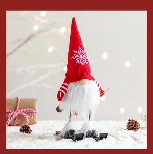 Close-up of a festive skiing Christmas gnome with a red hat and white beard on a snowy background