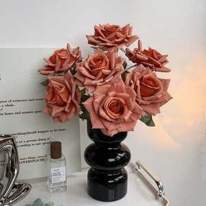 Coral artificial roses in a sleek black glossy vase for elegant home table decoration