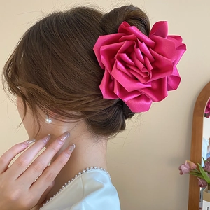Gros plan sur une pince à cheveux élégante en satin rouge rose avec fleur en relief