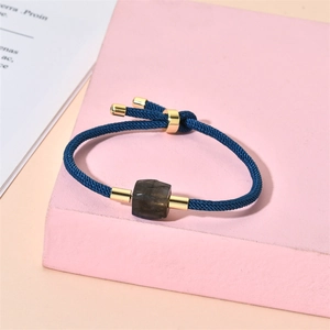 Détail du bracelet en corde bleue ajustable avec pendentif en pierre carrée sur support