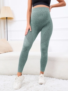 Detail view of sage green maternity leggings featuring breathable cutouts at the knees