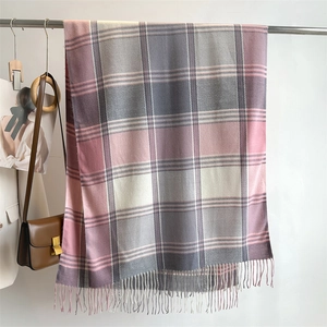 Detail of grey and pink plaid scarf with soft tassels and warm wool-like texture
