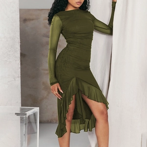 Détail d'une robe moulante en tulle vert armée avec fronces et ourlet à volants